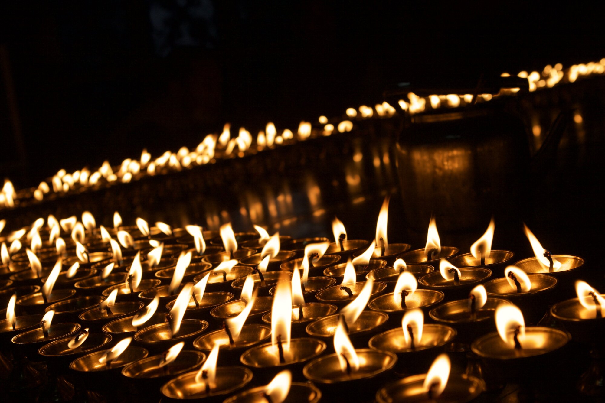 Two rows of lit votive candles.