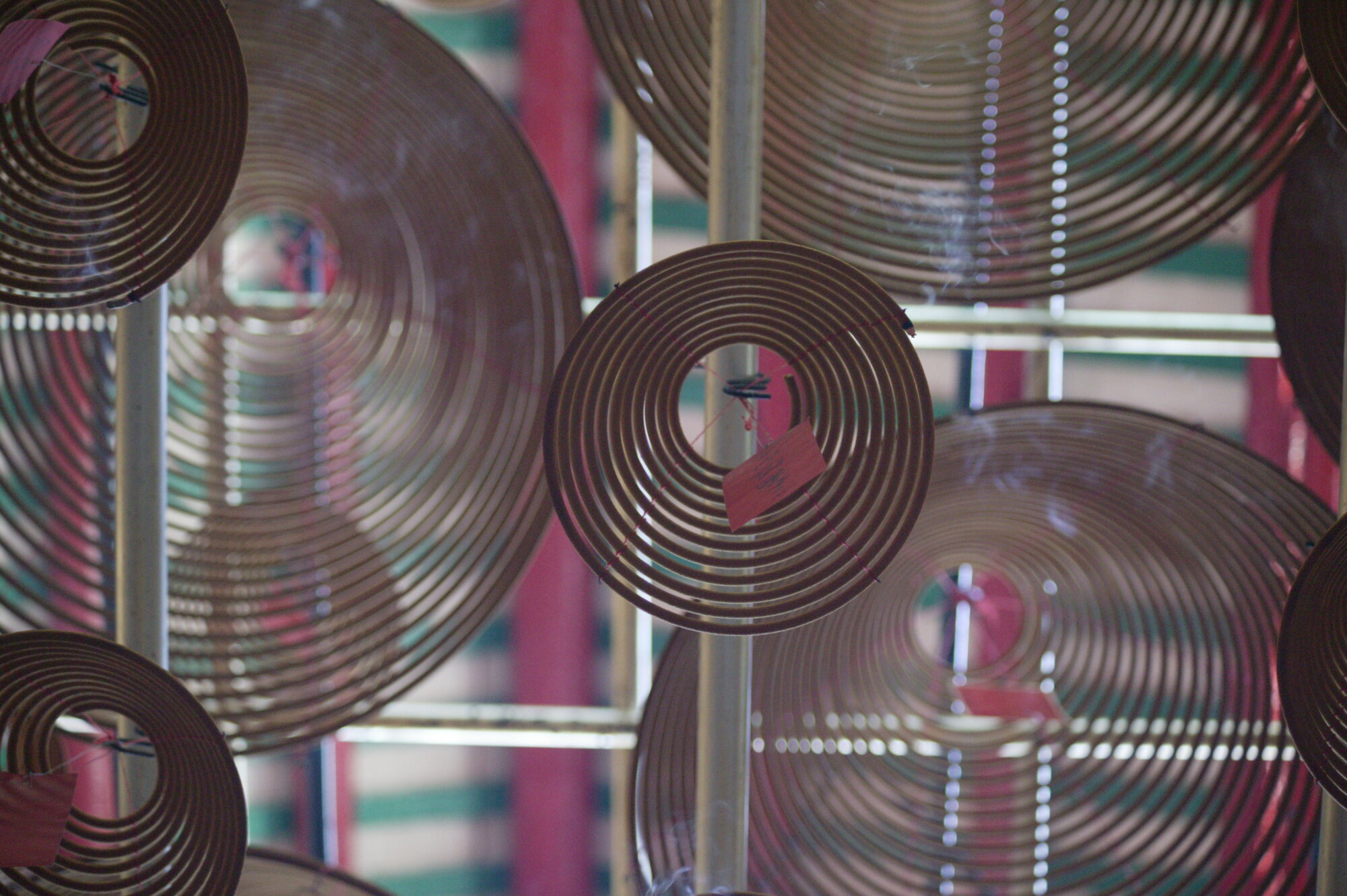 Hanging coil-style incense burners viewed from below.